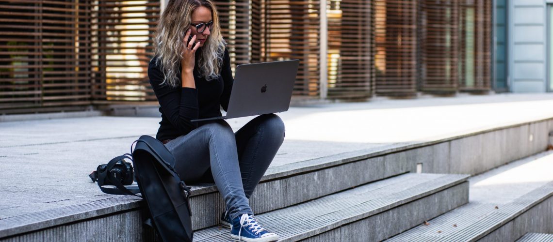 woman-sitting-on-stairs-while-using-laptop-1438075